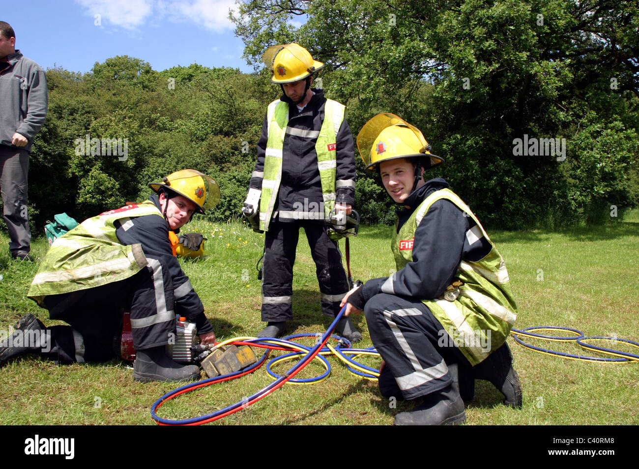 Firemen stowing cutting gear at the scene of an accident Stock Photo
