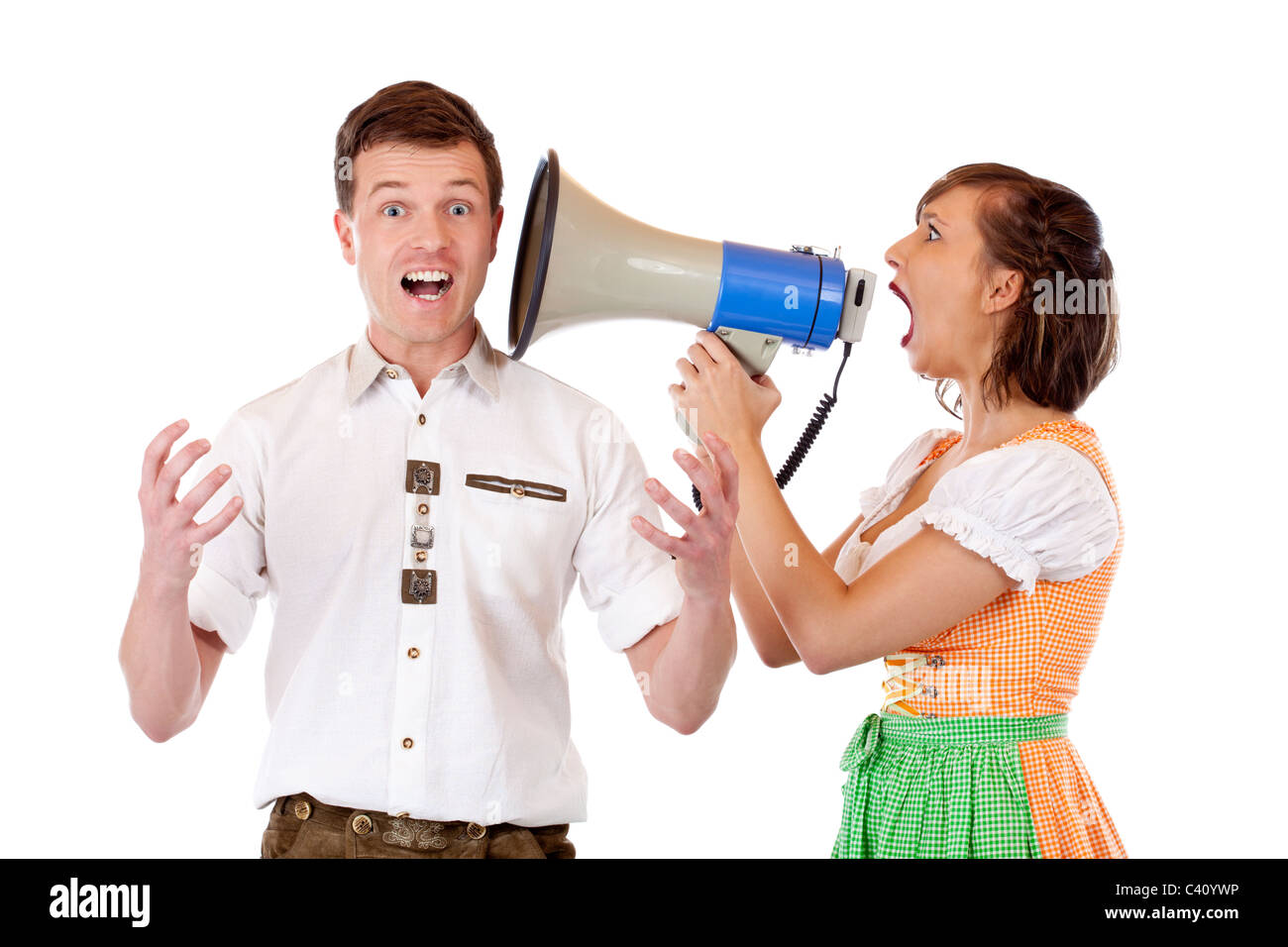 Pretty woman with dirndl screams in megaphone to Bavarian man Stock Photo