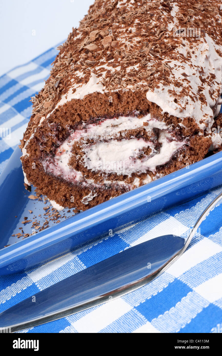 Chocolate swiss roll cake with berries marmalade and whipped cream over ...