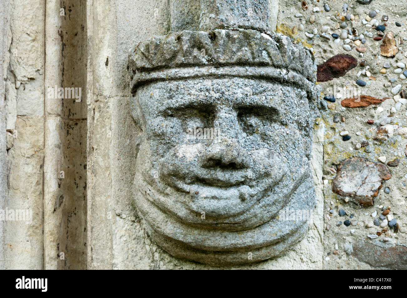 Stone carving of a humorous head on the south porch of St Andrew's church, Shalford in Essex. Stock Photo