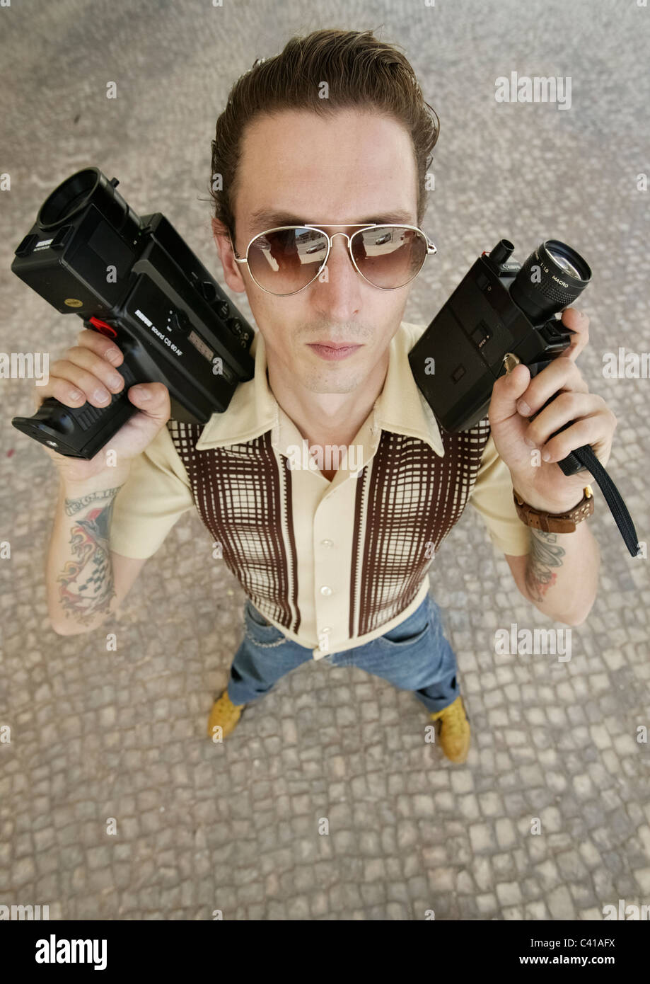 High angle portrait of man holding old super-8 film cameras Stock Photo