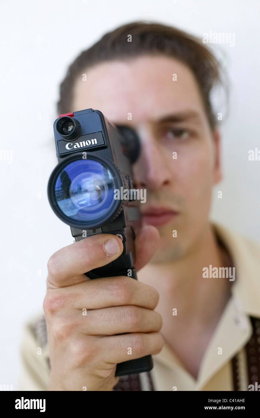 Selective focus portrait of man holding a Canon old super-8 film camera Stock Photo