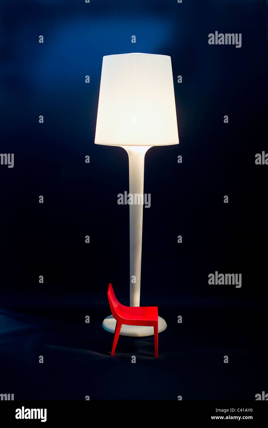 Modern Spanish furniture design featuring a very big lamp and tiny plastic chair Stock Photo