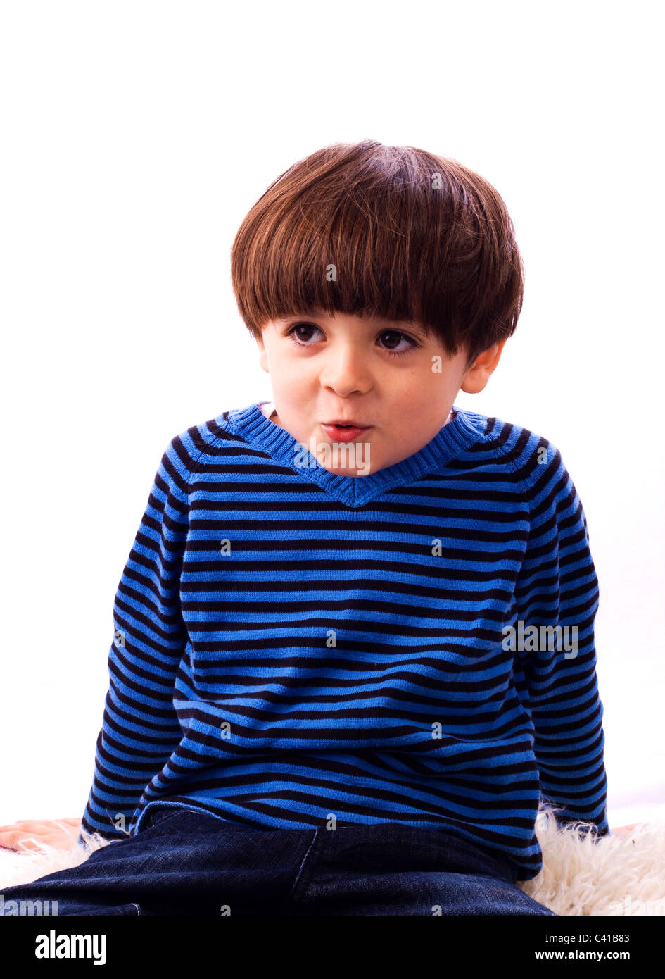 Young boy in blue top looking puzzled Stock Photo Alamy