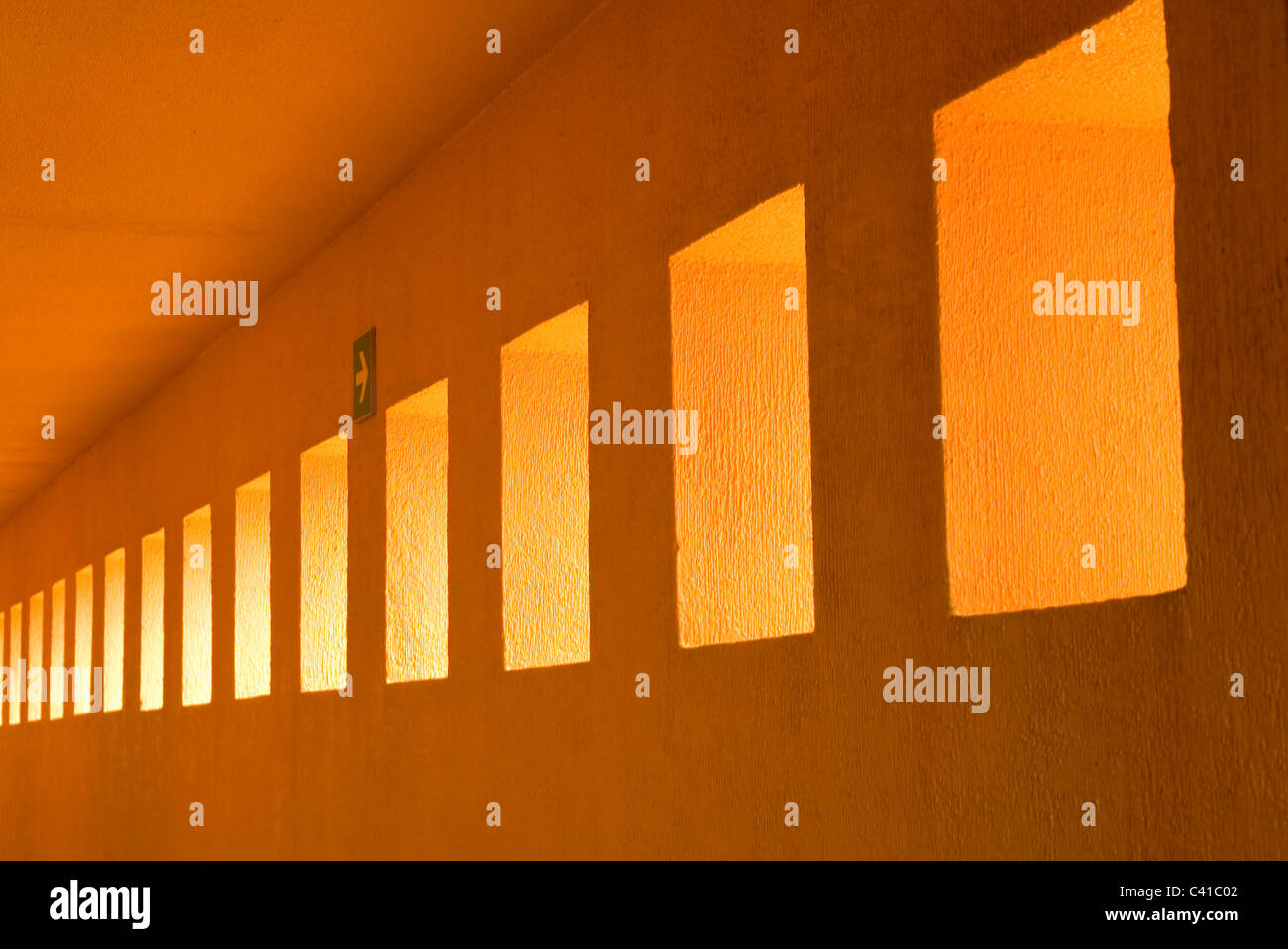 abstract photo of geometric shapes showing a row of rectangular wall cutouts leading to a vanishing point along a portico wall Stock Photo