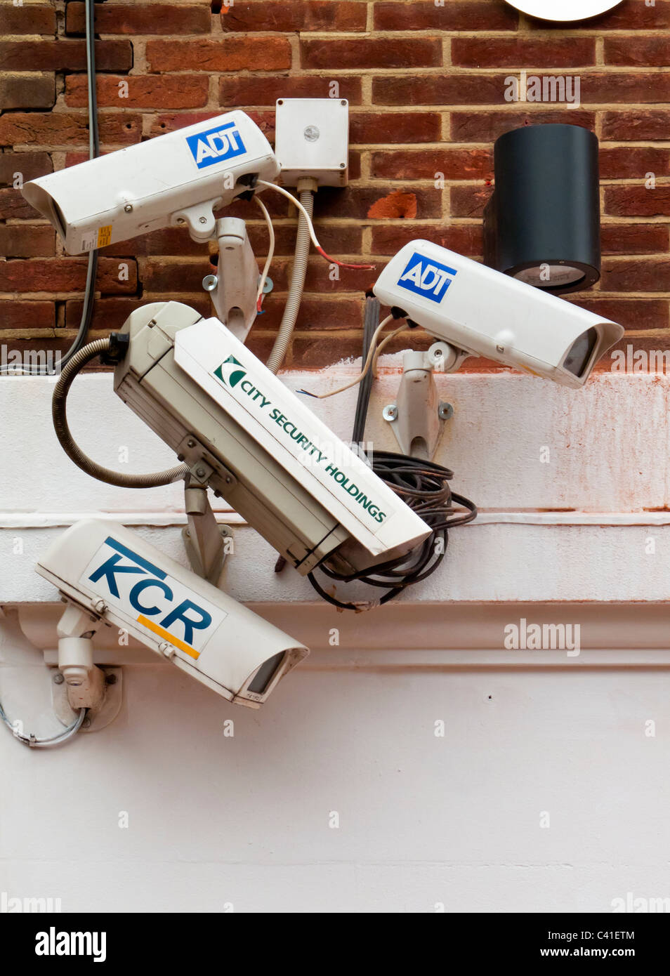 Group of four CCTV security cameras mounted on a wall in the UK Stock