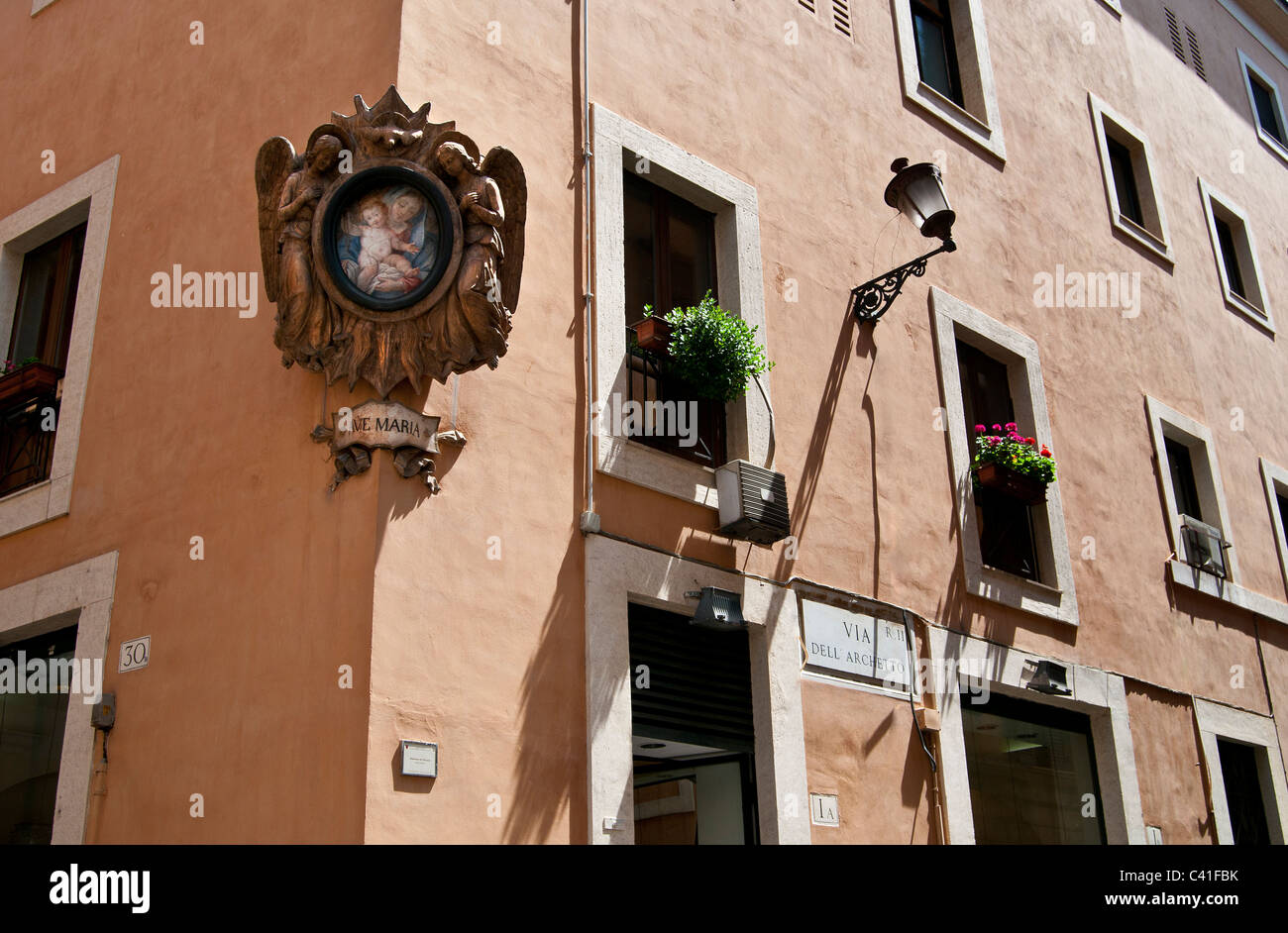 Ave Maria painting with decorated wooden frame on street corner and traditional italian house in [ Rome Italy) Stock Photo