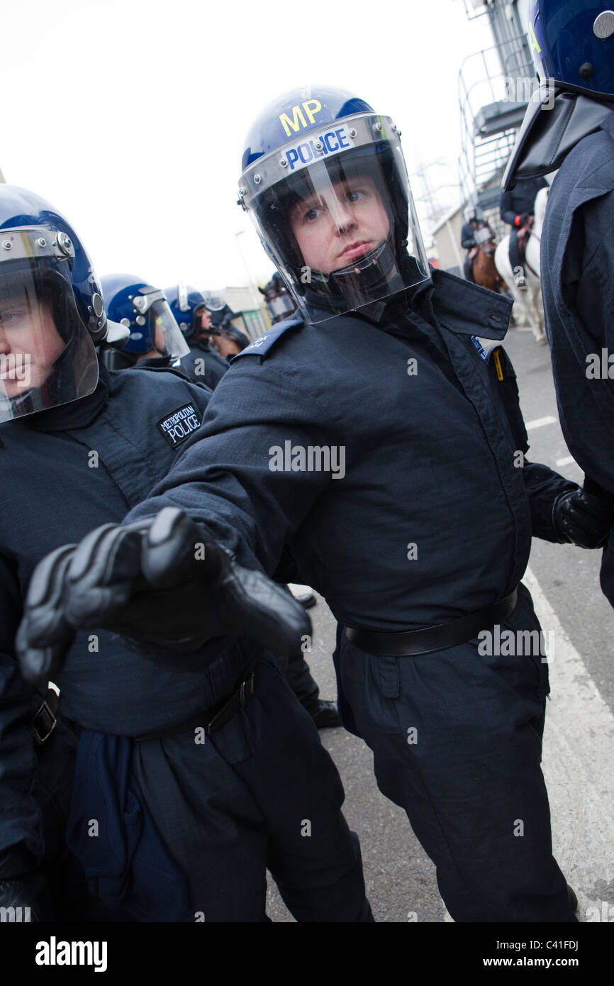A police officer in riot gear reaches towards the camera Stock Photo
