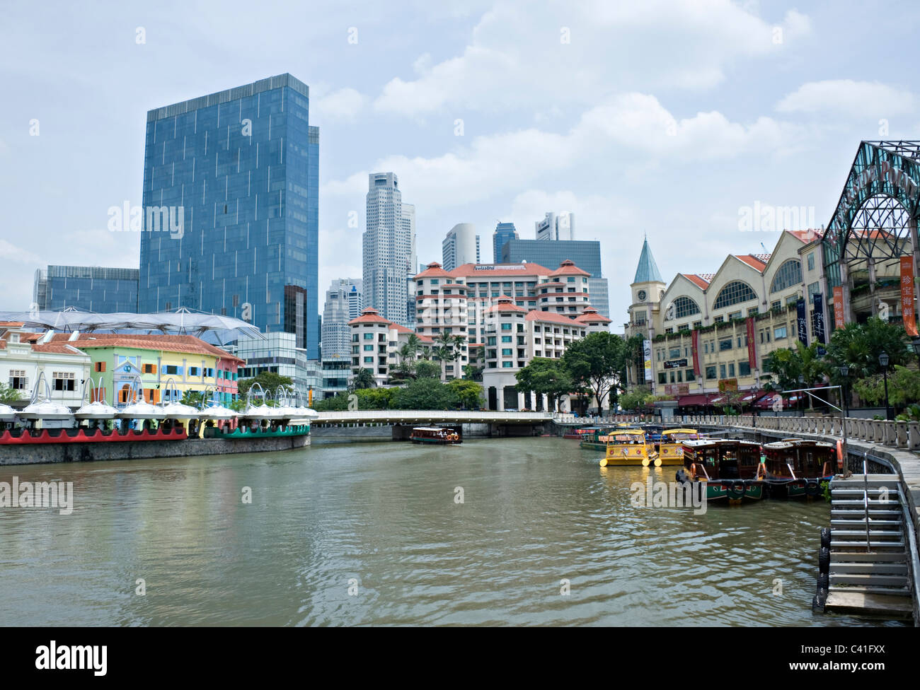 Swissotel Merchant Court with The City Skyscrapers Behind and Boats on Singapore River near Clarke Quay Republic of Singapore Stock Photo
