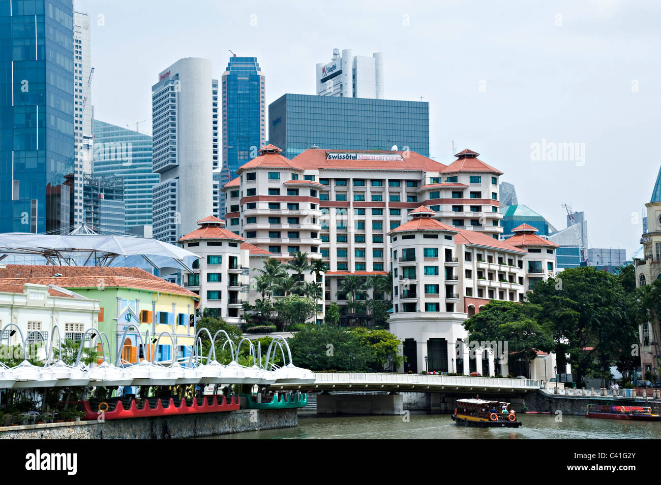 Swissotel Merchant Court with The City Skyscrapers Behind and Boats on Singapore River near Clarke Quay Republic of Singapore Stock Photo