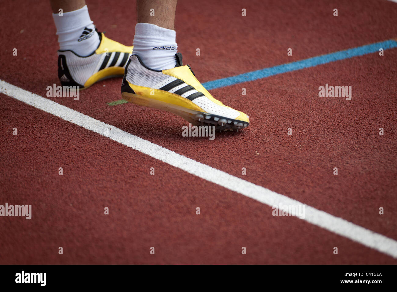 High resolution image of sprinter feet wearing Adidas sport shoes and  preparing to start Stock Photo - Alamy