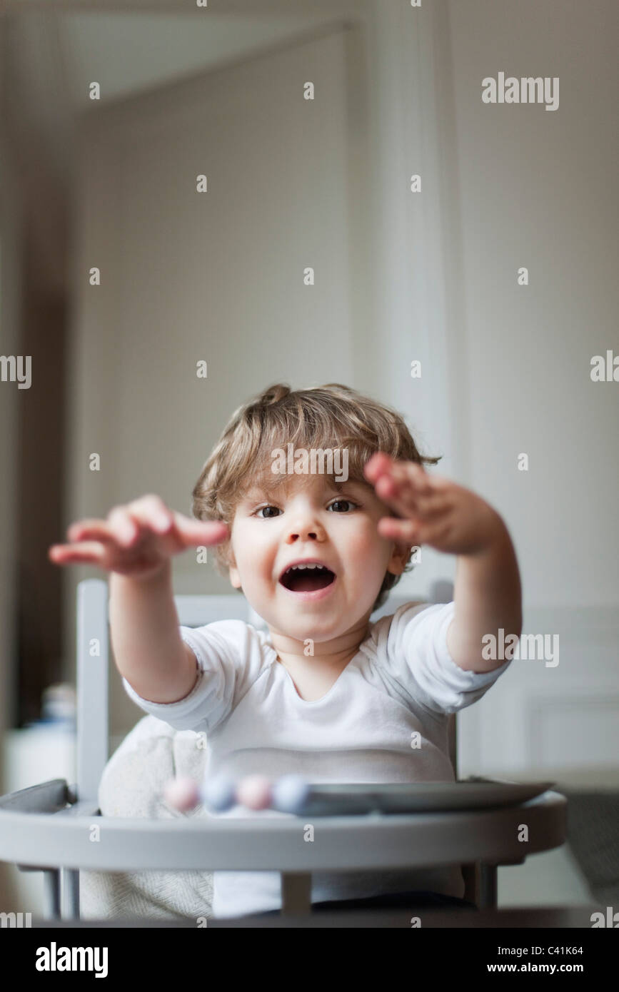 Toddler boy playing in high chair Stock Photo - Alamy