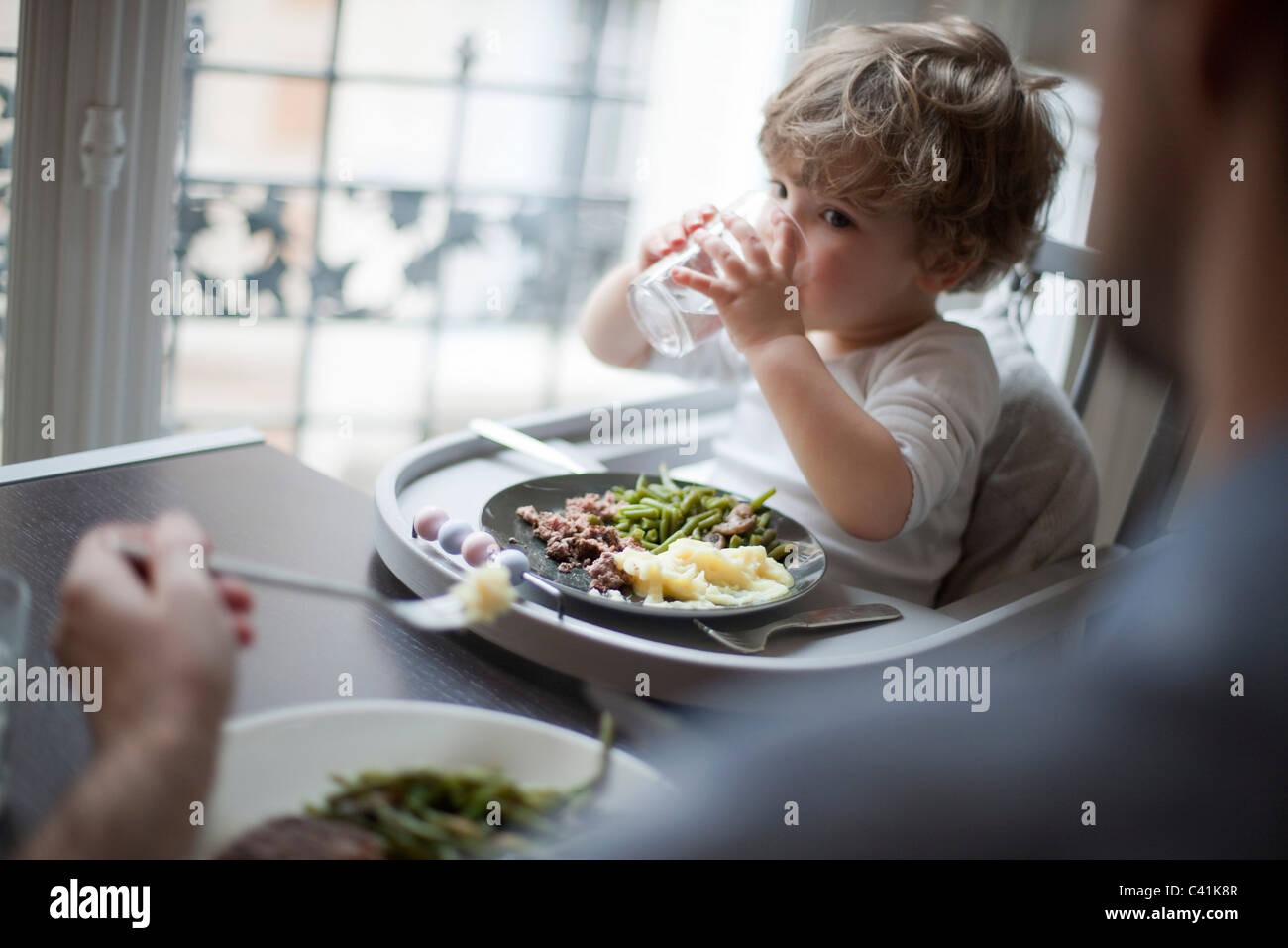 Toddler boy drinking glass of water Stock Photo Alamy