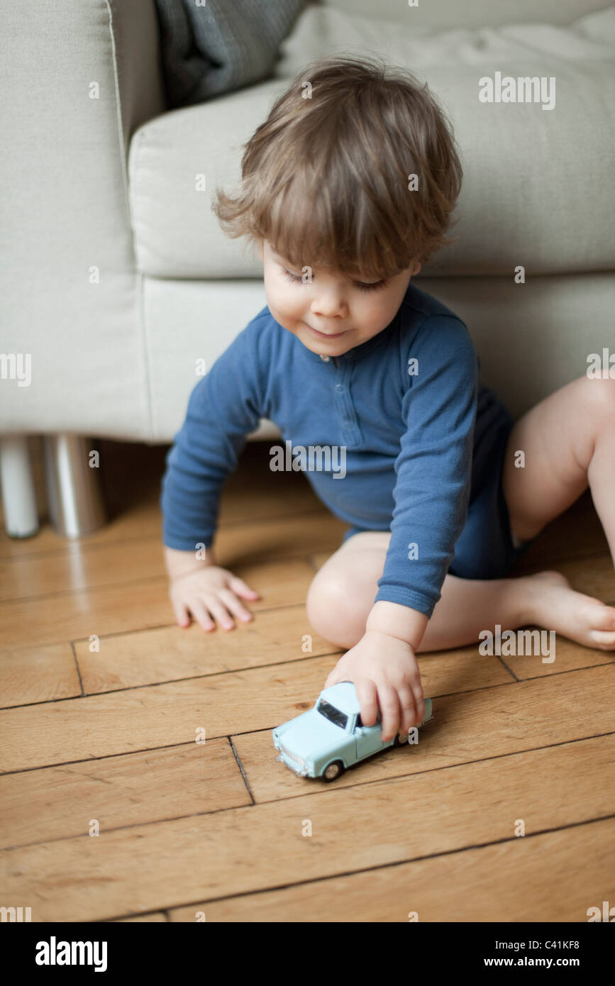 Toddler boy playing with toy car Stock Photo - Alamy