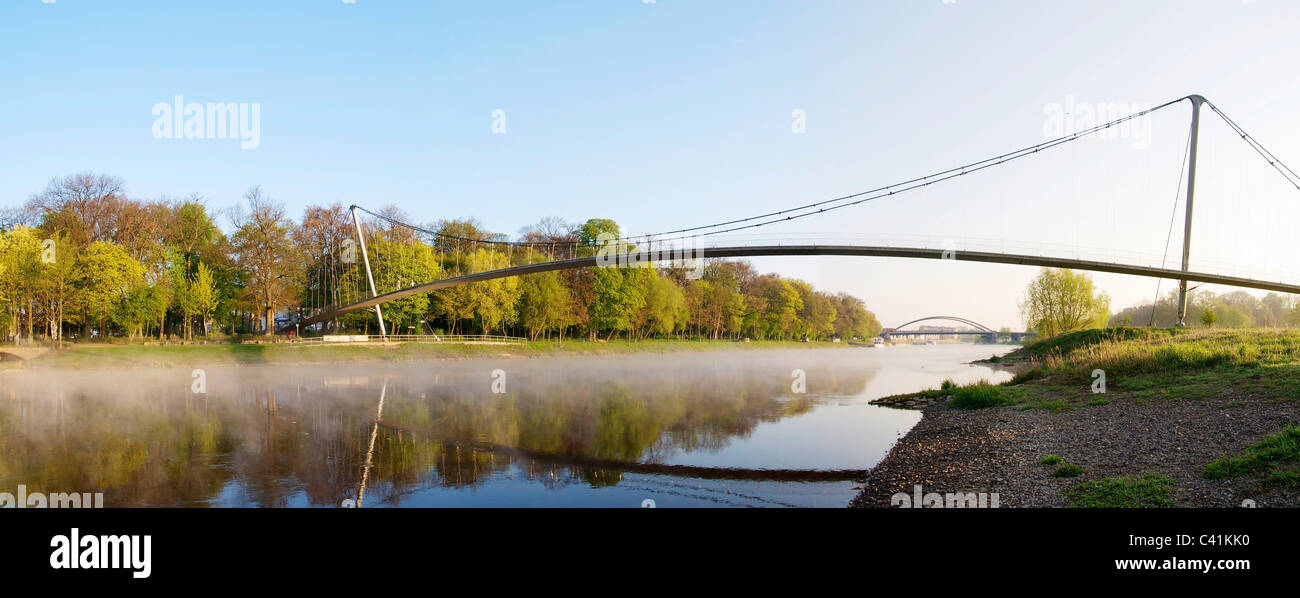 Glacis footbridge (1995) in Minden in the morning.  The 177 meters long suspension bridge is crossing the Weser river. Stock Photo