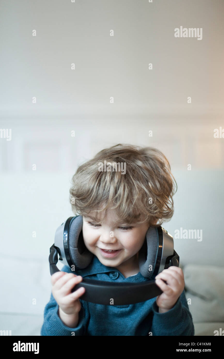 Toddler boy playing with headphones, portrait Stock Photo Alamy