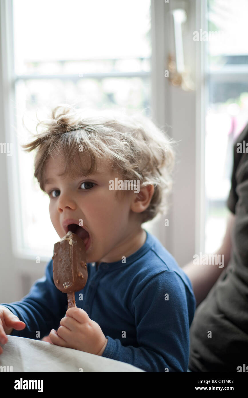 Toddler boy eating ice cream bar Stock Photo Alamy