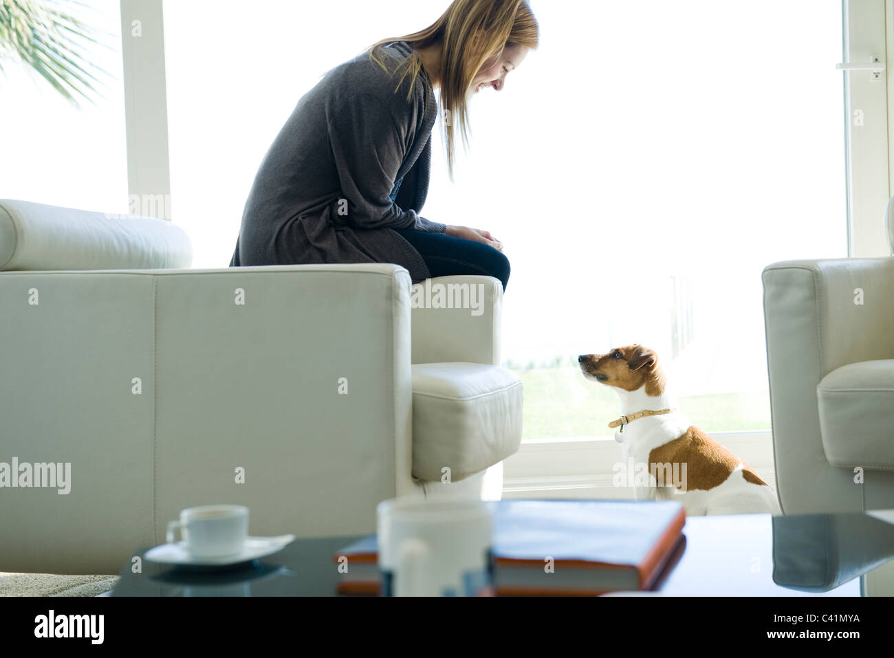 Woman relaxing in living room with dog Stock Photo - Alamy