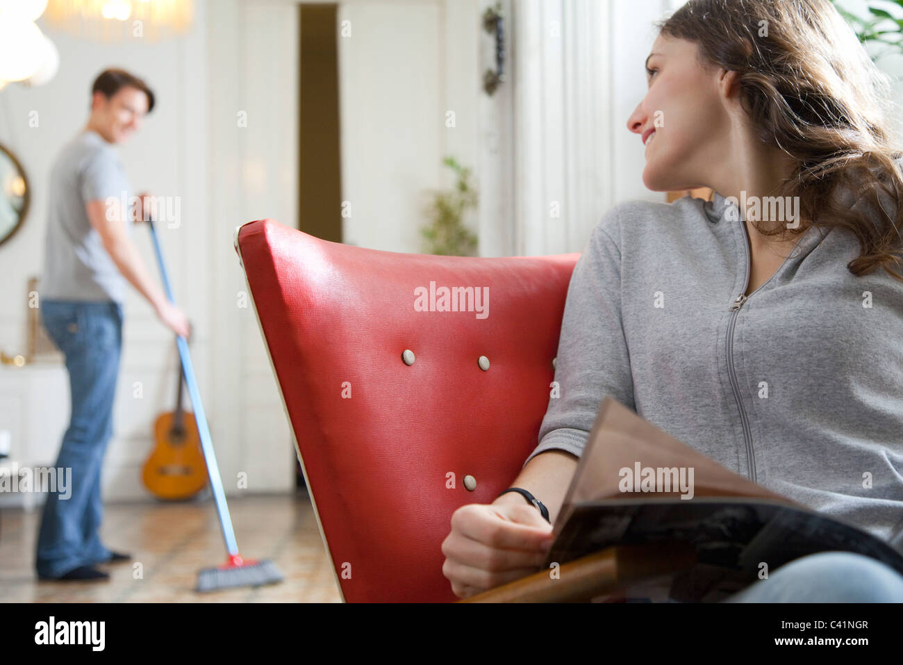 Woman smiling over shoulder at husband as he sweeps the floor Stock Photo 36918247 Alamy