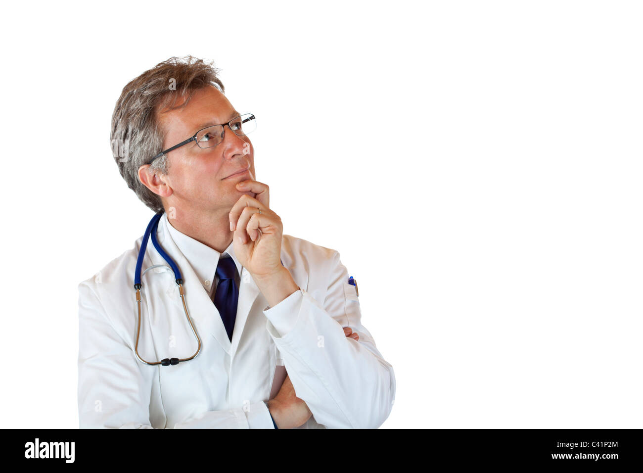 Aged medical doctor with hand on chin looks contemplative up. Isolated on white background. Stock Photo