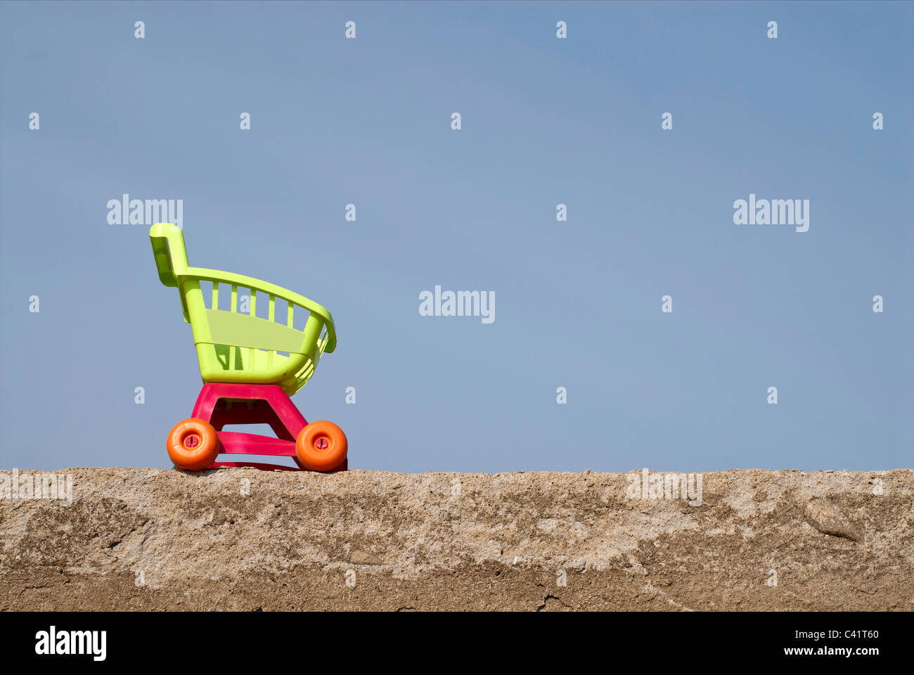 shopping trolley sitting on a rock wall,on a blue cart