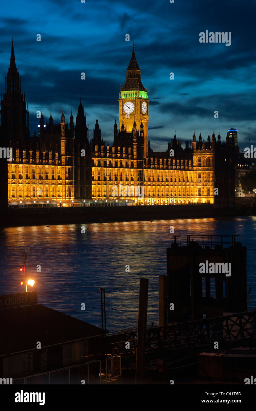The Houses of Parliament in the Palace of Westminster beside the River Thames in London, England, UK. Illuminated at dusk/night. Stock Photo