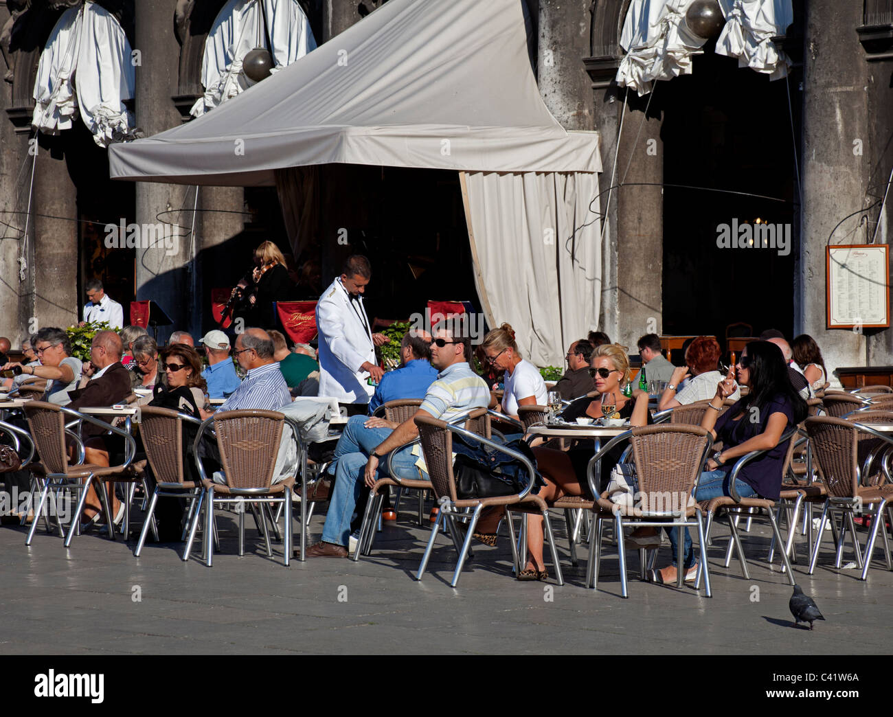 Venice people tourists sitting at cafe in St Mark's Square Italy Europe Stock Photo