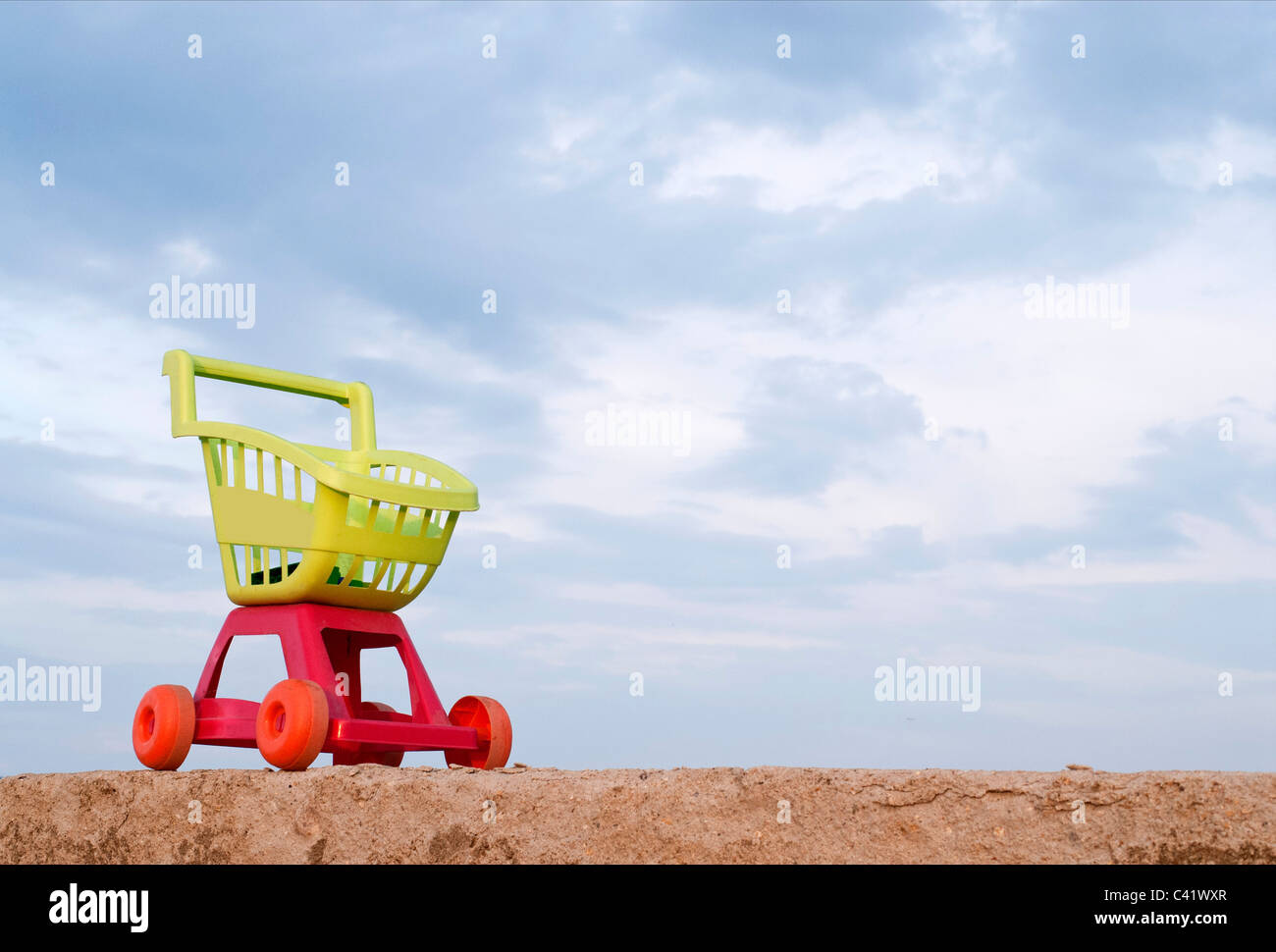 shopping trolley sitting on a rock wall,on a blue cart