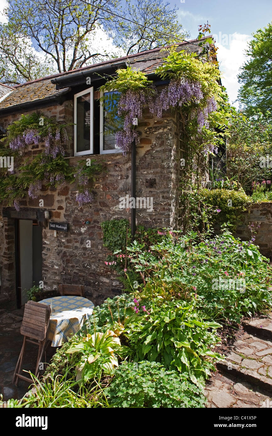 Old mill building covered in wisteria. Stock Photo