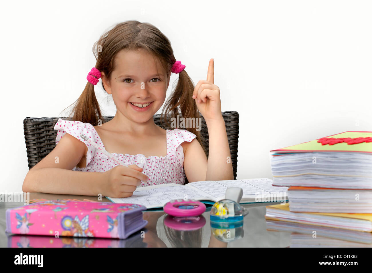 7 year old girl at the table with homework Stock Photo