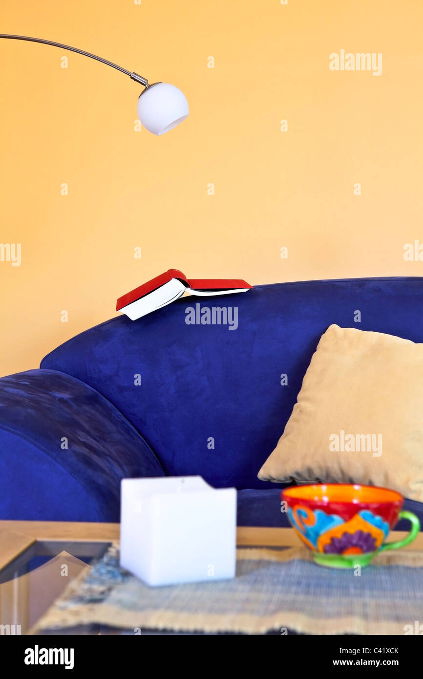 a reading corner with a blue couch, a book and a reading lamp Stock Photo