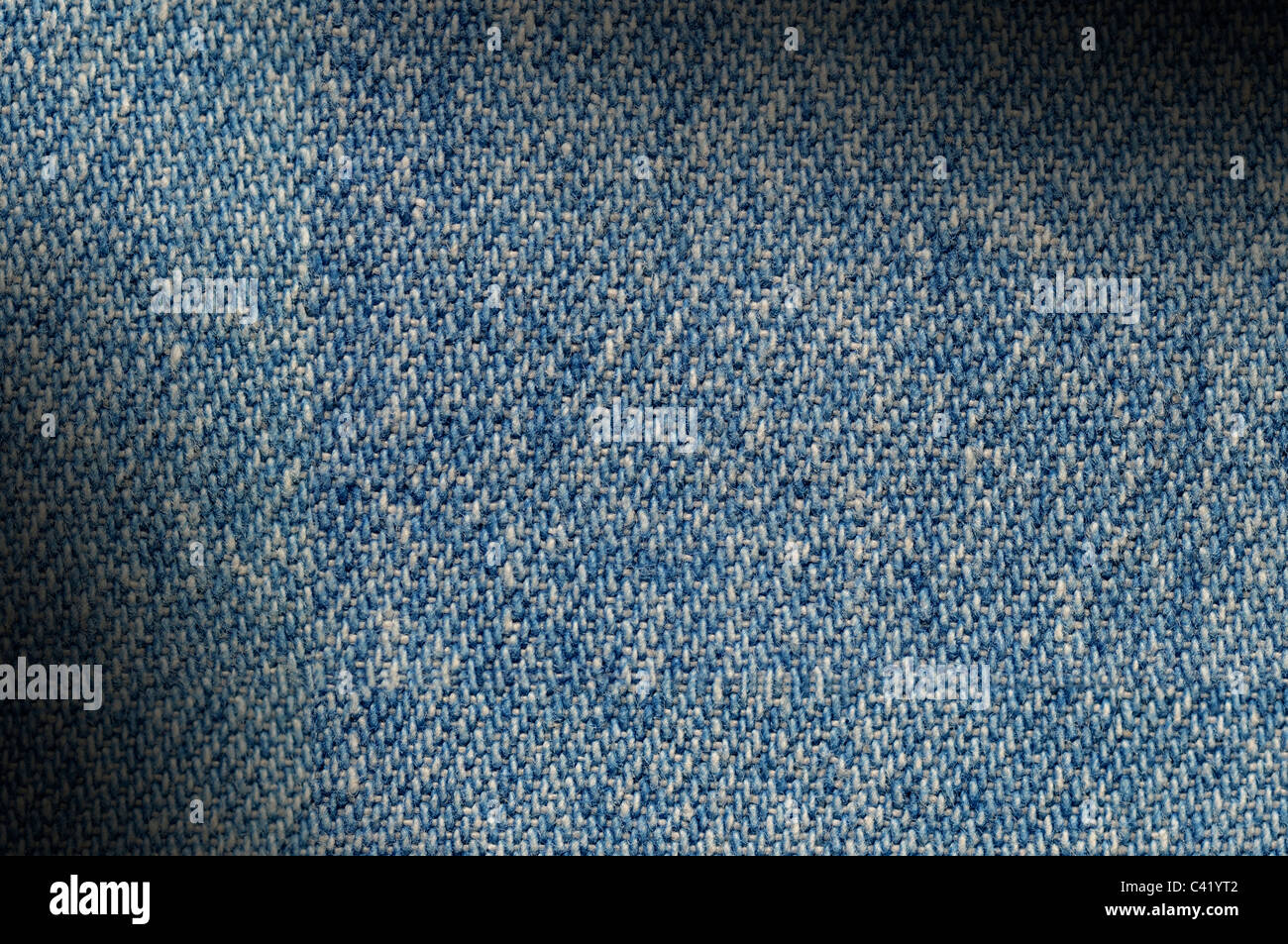 Blue denim fabric texture background lit diagonally Stock Photo