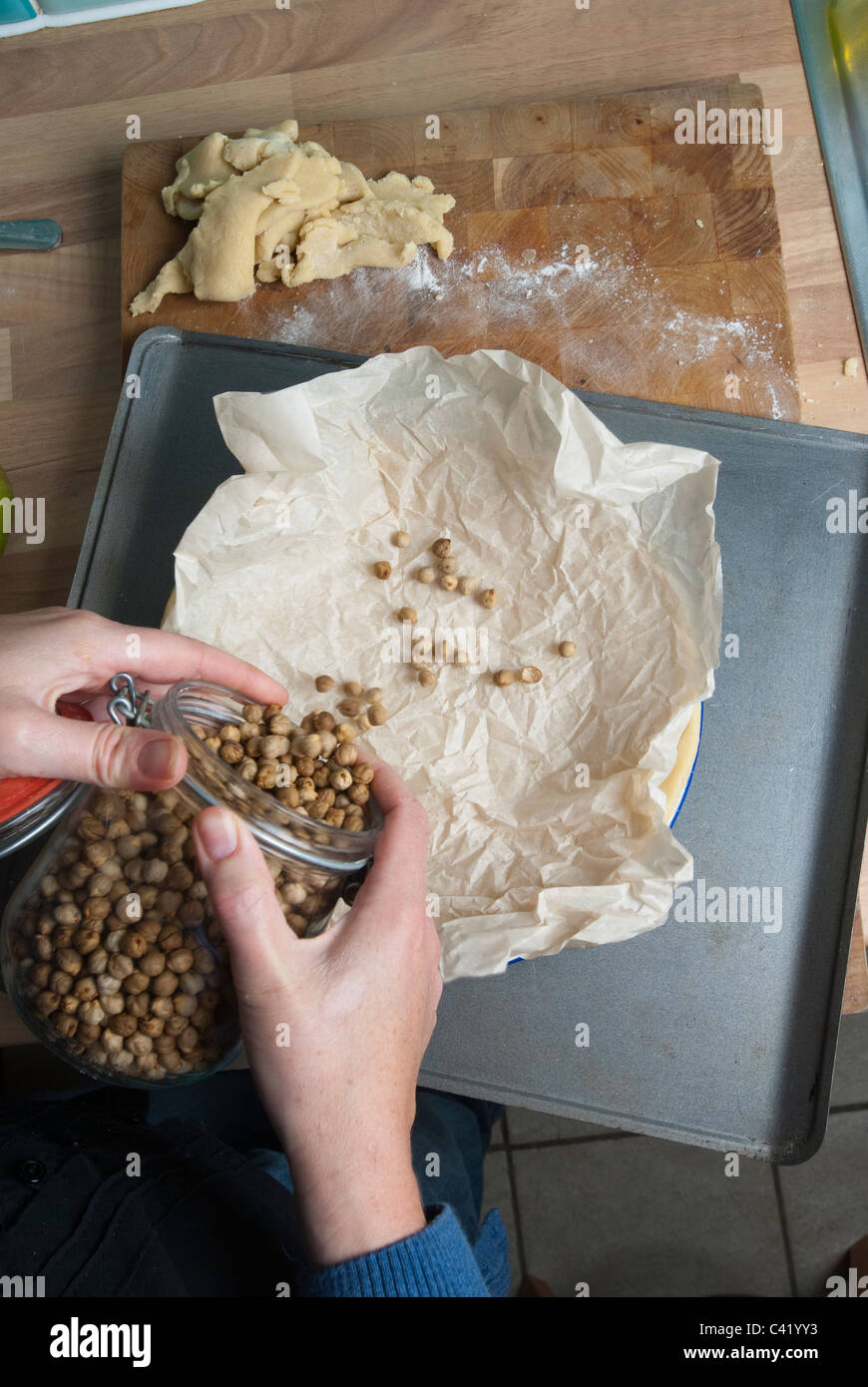 Blind baking beans being poured into a piece of grease proof paper UK Stock Photo Alamy