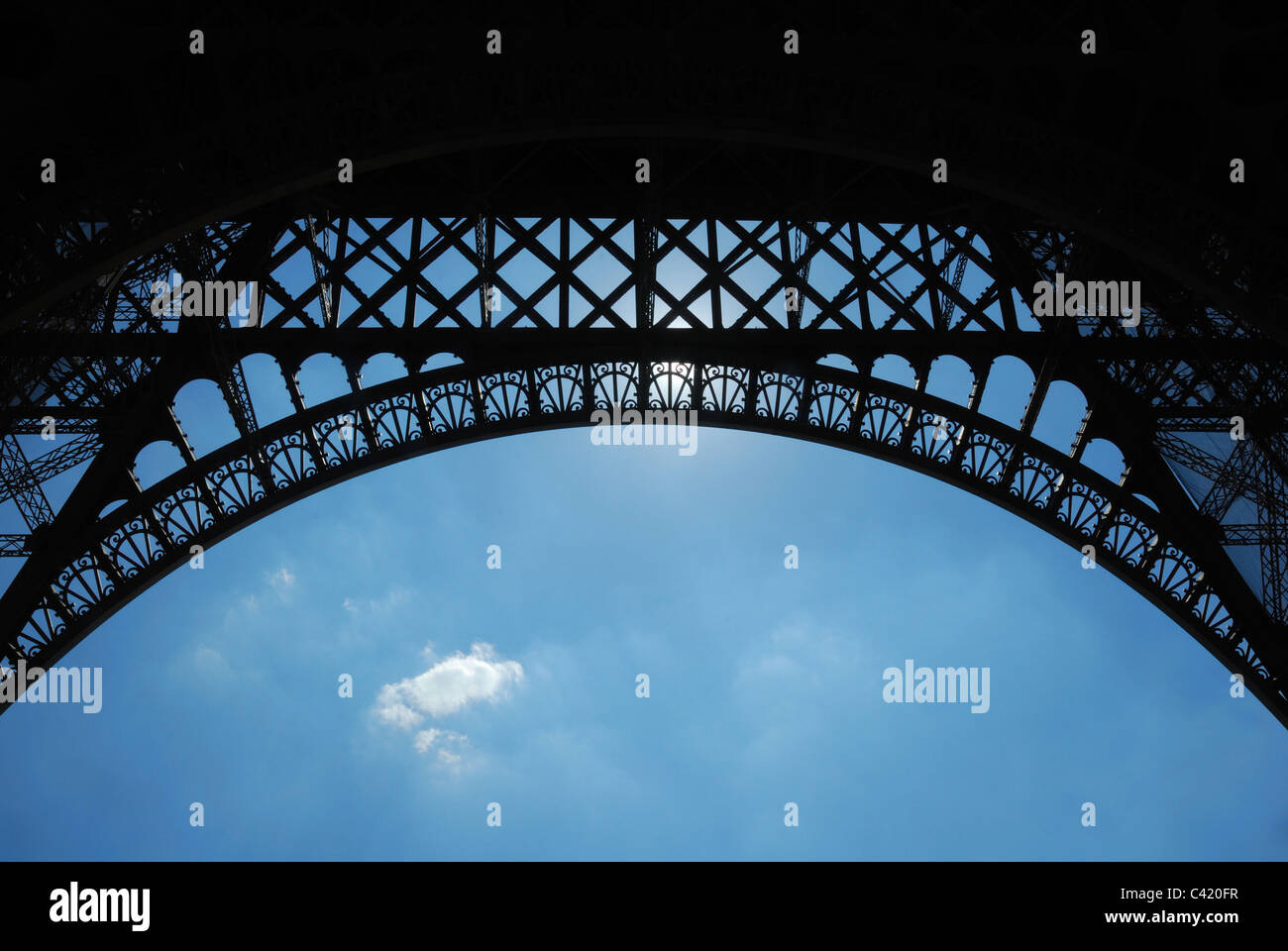 Small clouds under the arch of the Eiffel Tower Stock Photo