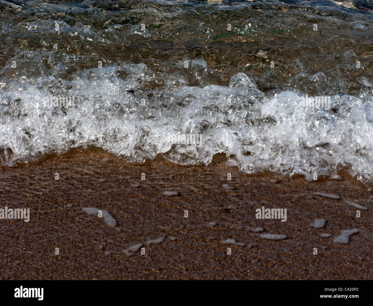 ABSTRACT IMAGE OF WAVES LAPPING ONTO A BEACH Stock Photo
