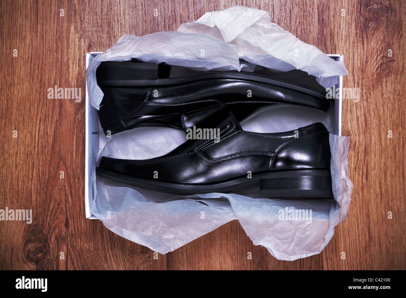 Photo of a pair of new mens shoes in a shoe box on rustic wooden floor Stock Photo