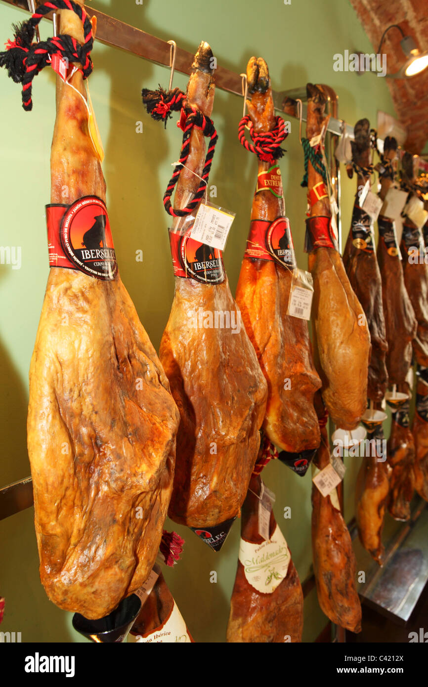 Iberian ham hangs in a delicatessen in Merida, in the Extremadura district of Spain. Stock Photo