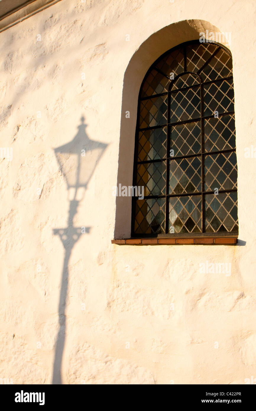 Shadow of a lamppost at sunset at Viken Kyrka Stock Photo