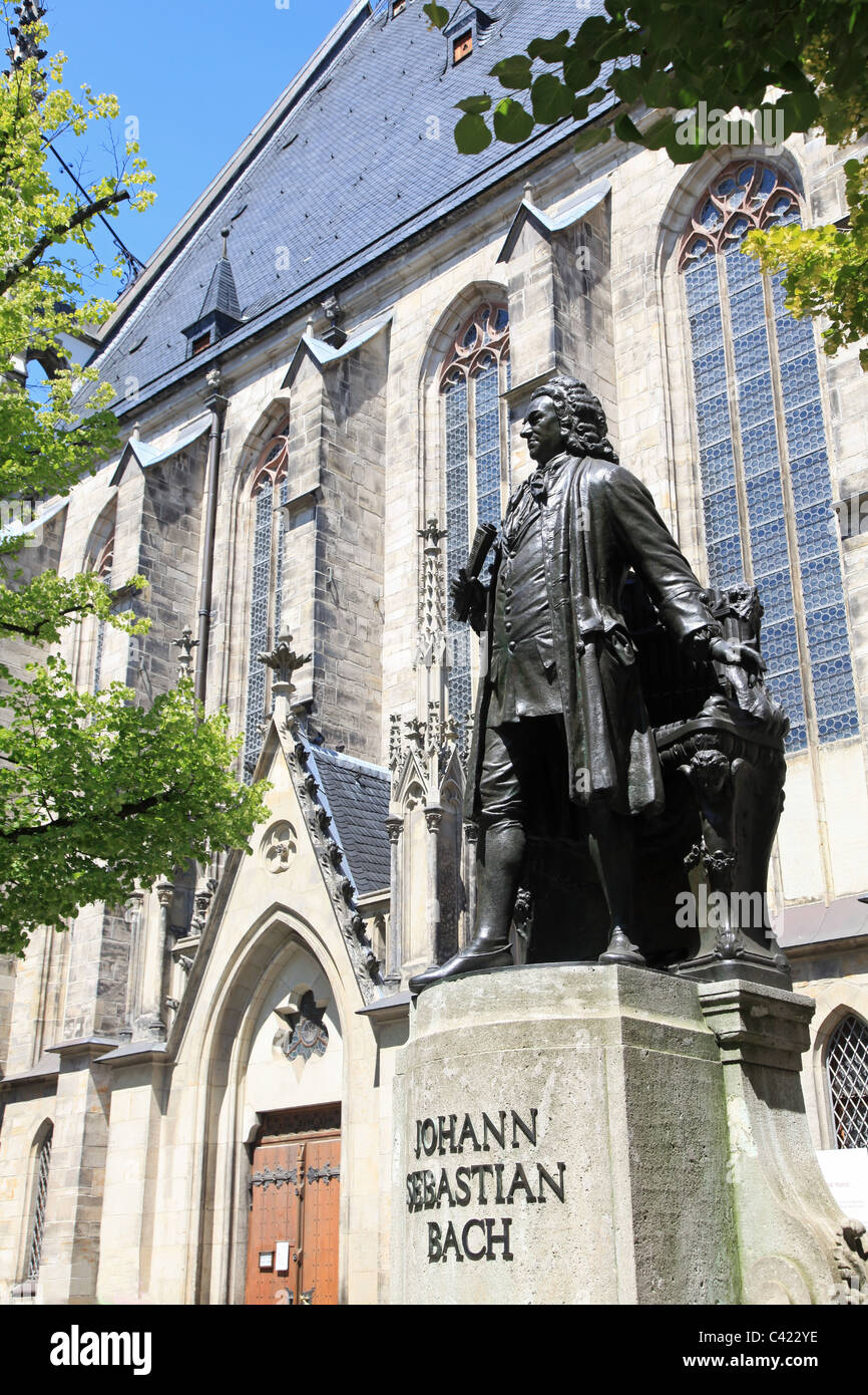 Statue of the classical composer Johann Sebastian Bach in his hometown Leipzig, Germany. Behind him is the famous Thomas church. Stock Photo