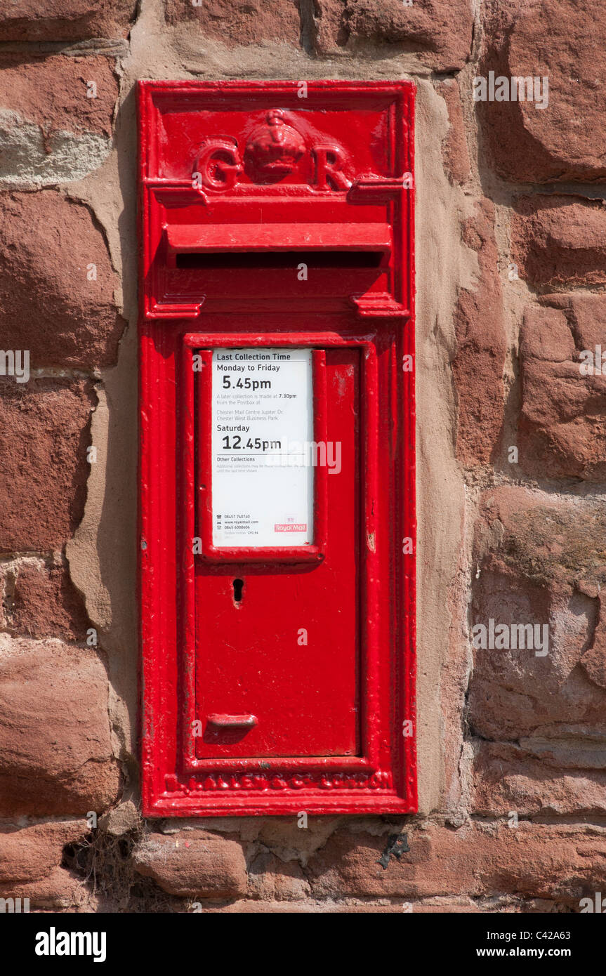 Red postbox in a stone wall, Chester, England. Stock Photo
