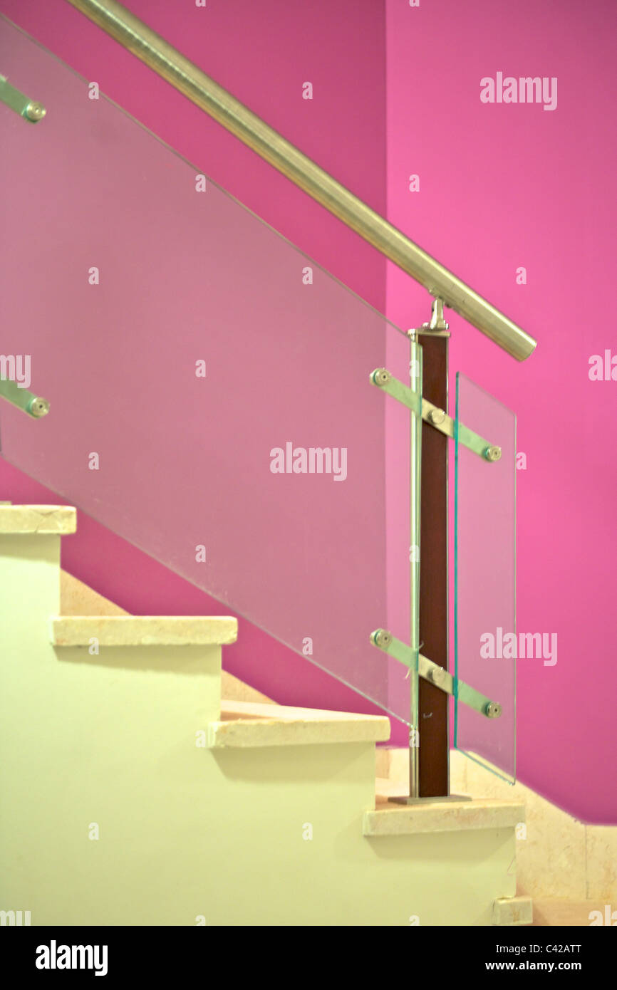 Pink wall, stairs and hand rail Stock Photo