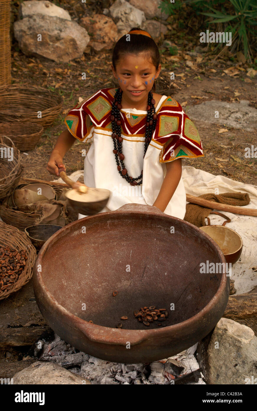 Maya girl roasting cacao beans at a Mayan market, Sacred Mayan Journey 2011 event, Xcaret Park, Riviera Maya, Quintana Roo, Mexico Stock Photo