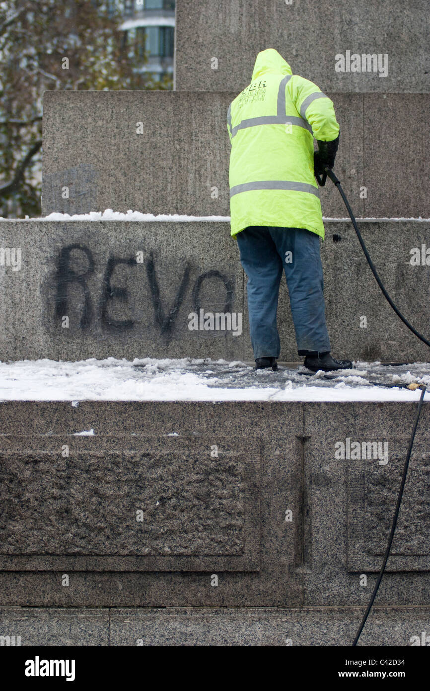 Graffiti from student protests is cleaned from Nelson's Column ahead of Christmas tree lighting ceremony in Trafalgar Square. Stock Photo
