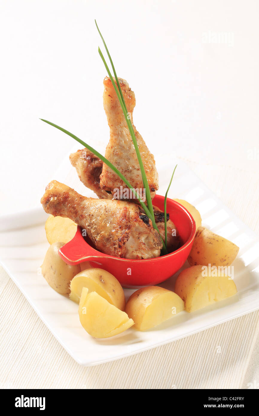 Roasted chicken drumsticks and new potatoes Stock Photo Alamy