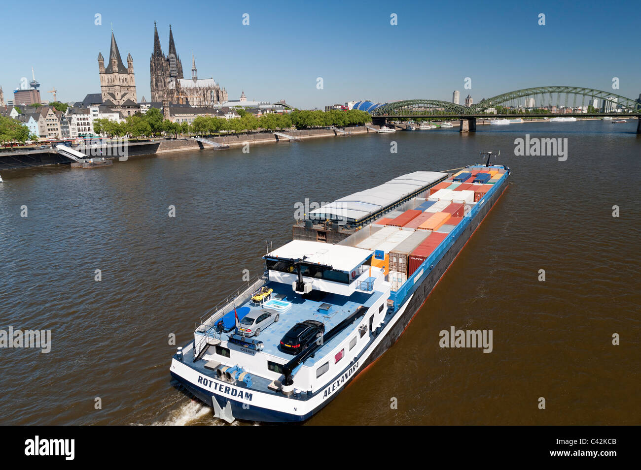 A Barge carrying shipping containers travels along the River Rhine in Cologne Germany Stock Photo
