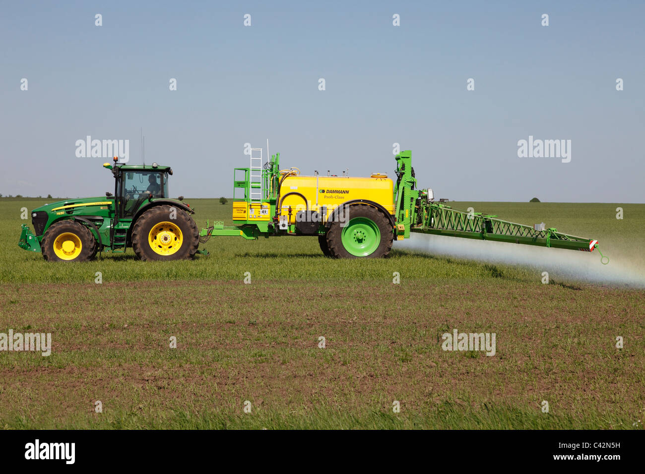 spraying herbicide in a grain field Stock Photo