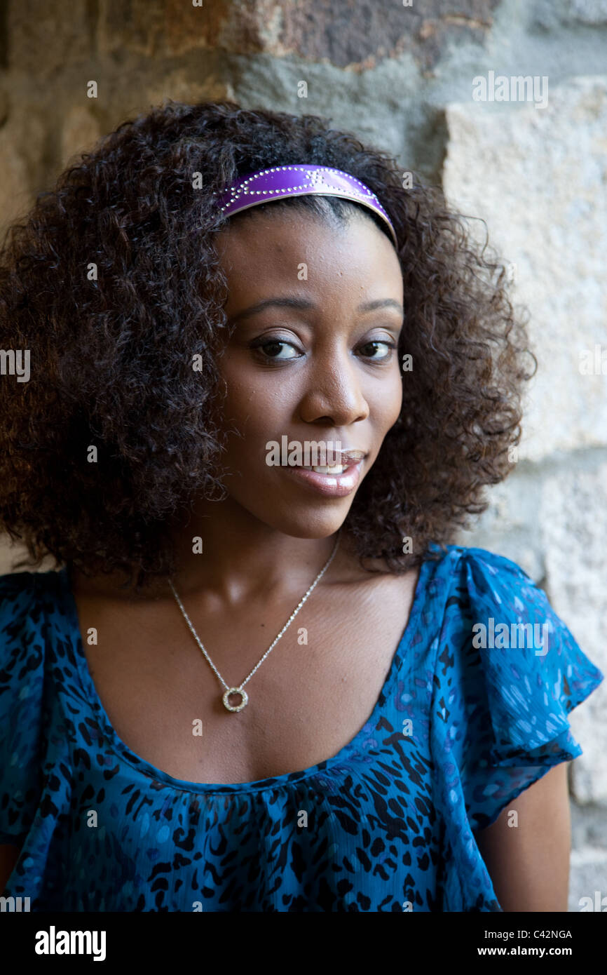 Pretty black woman  outside by a stone wall Stock Photo