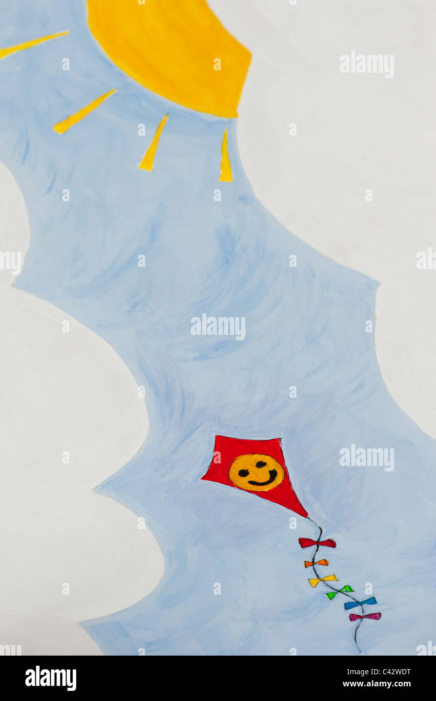 Childs painting of a happy smiling face on a kite in the sky Stock Photo