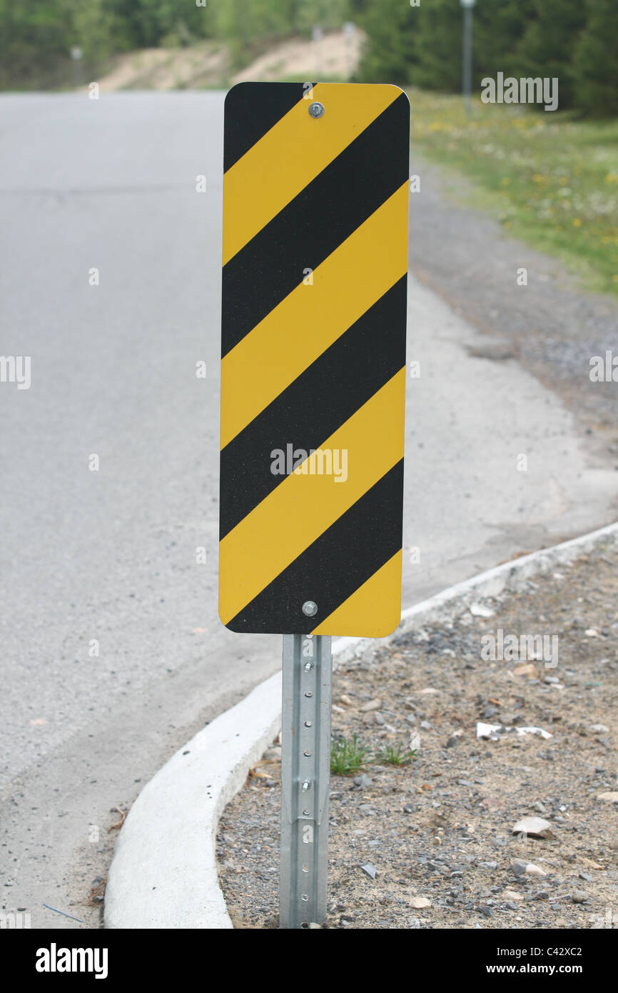 Yellow and black striped caution traffic sign Stock Photo