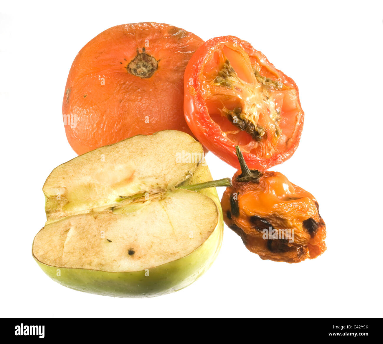 Old rotten tomatoes, a chili pepper and an apple which had all been left  in a refrigerator for a few weeks and are decaying. Stock Photo